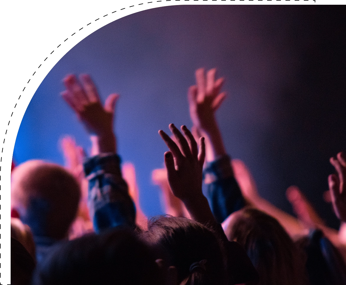 A crowd of people raising their hands in the air.