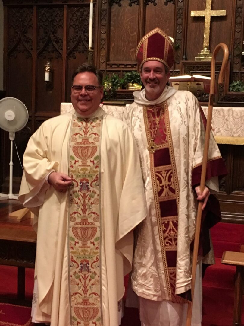 Two men in robes and hats standing next to each other.