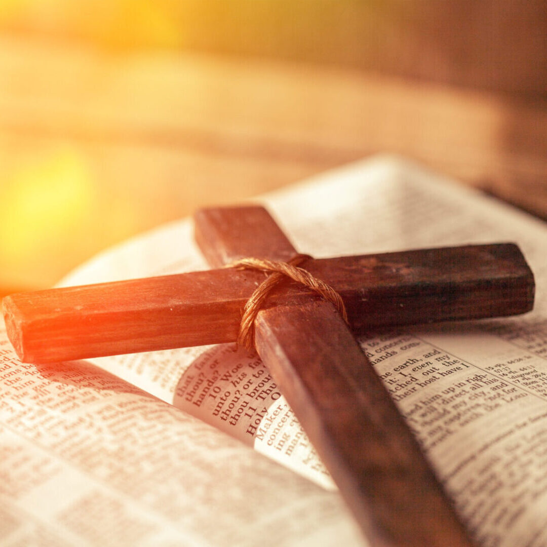 A cross on top of a newspaper with sunlight coming through.