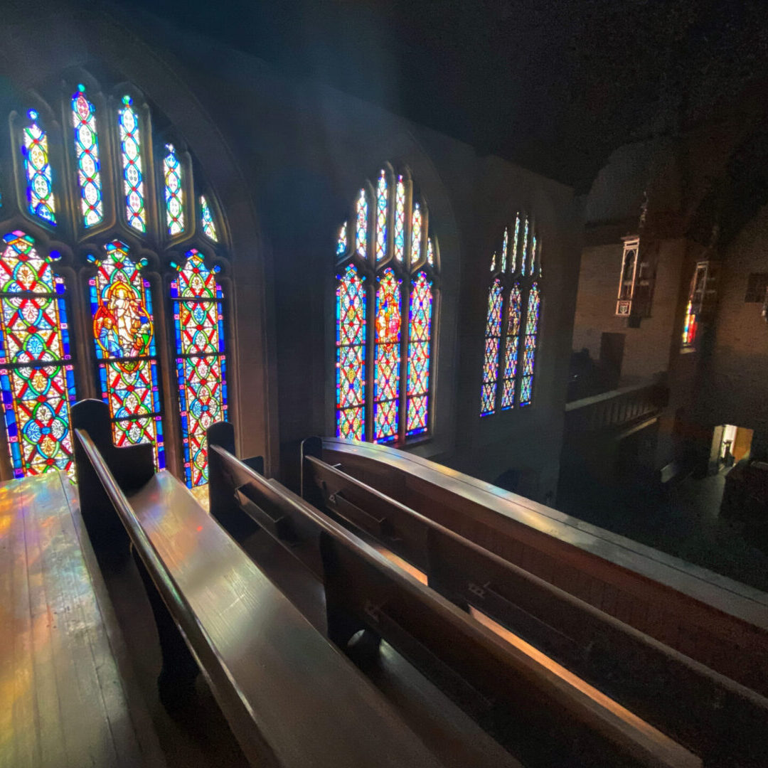 A church with stained glass windows and pews