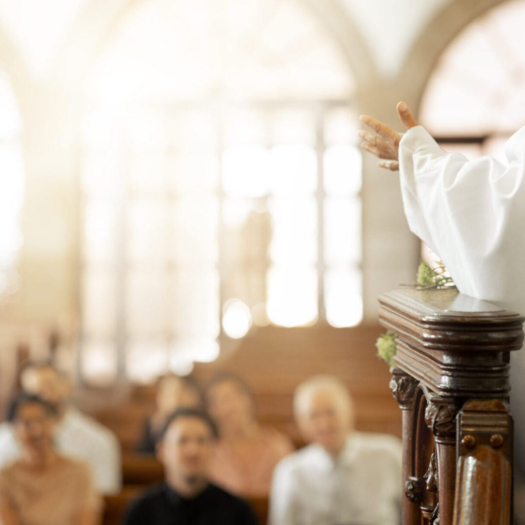 A priest is giving a sermon to the congregation.