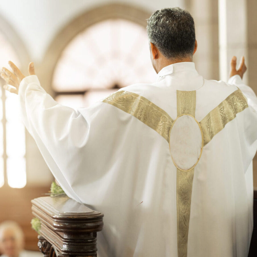 A priest is standing in front of the altar.