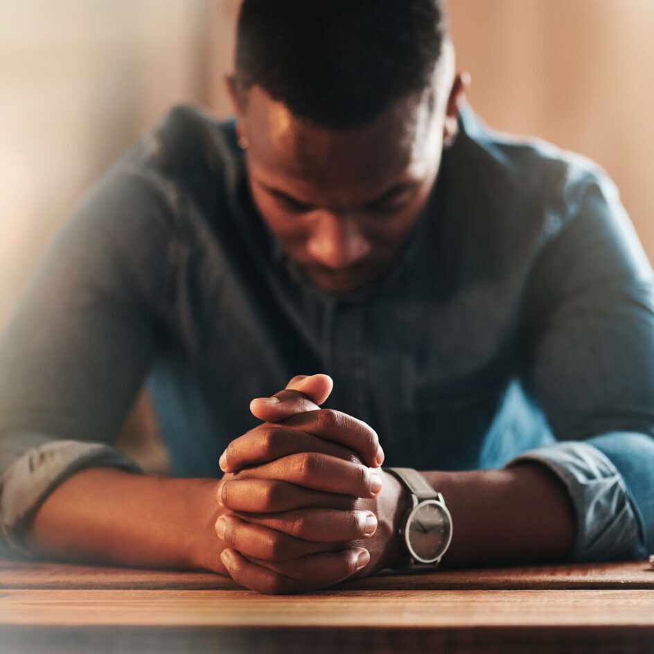 A man sitting at the table with his hands clasped together.