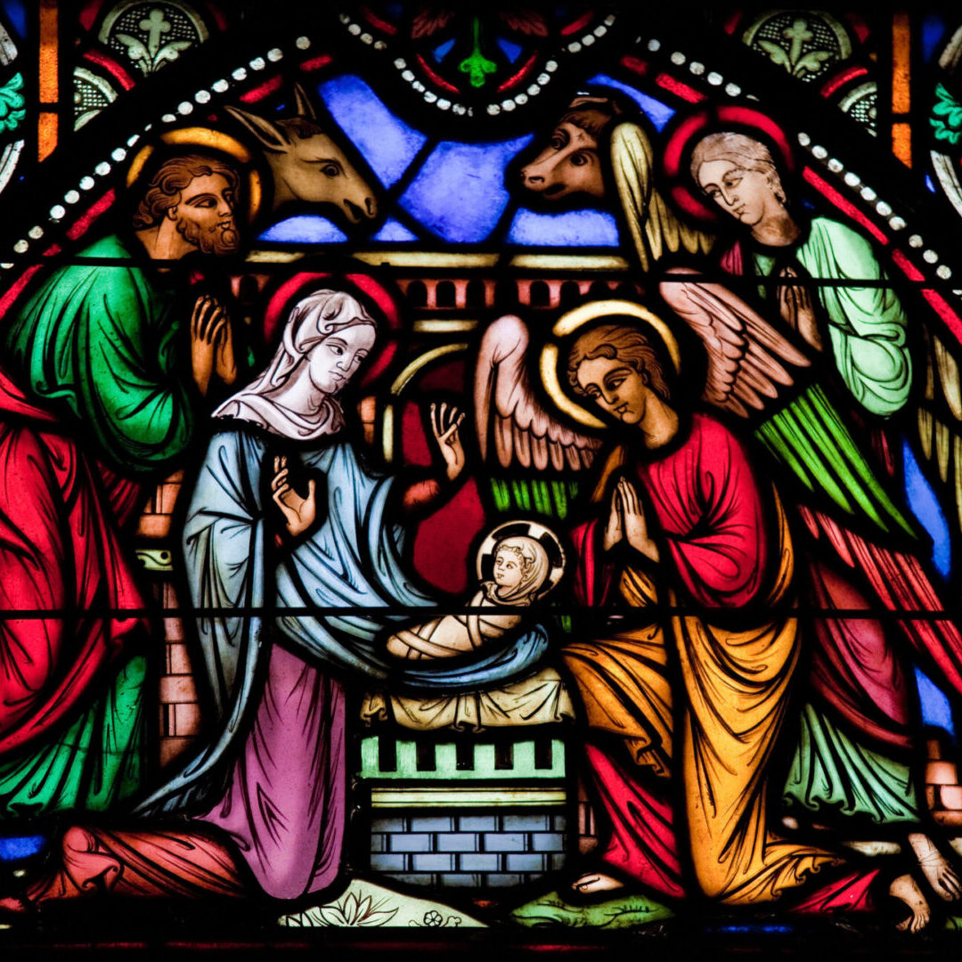 A stained glass window depicting the birth of jesus.