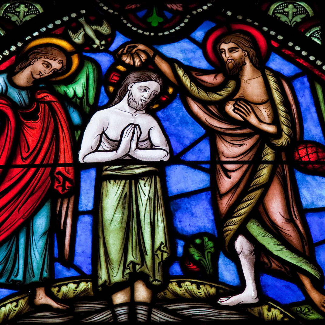 A stained glass window depicting jesus and two other people.