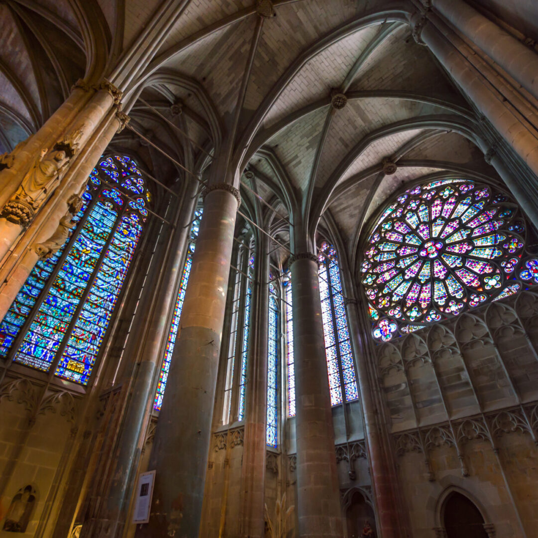 A cathedral with stained glass windows and pillars.