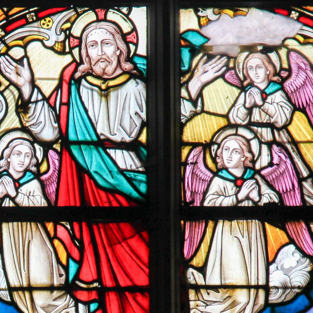 A stained glass window of jesus and angels.