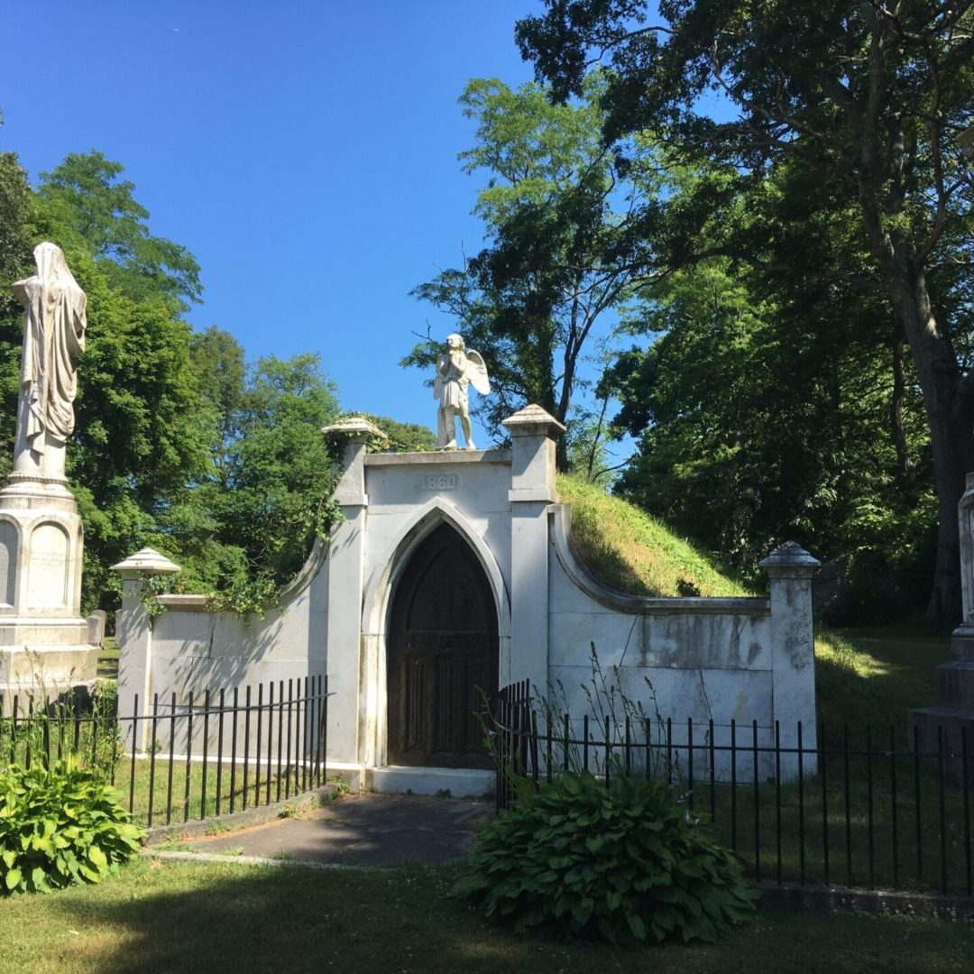 A cemetery with a white church and a statue of jesus.